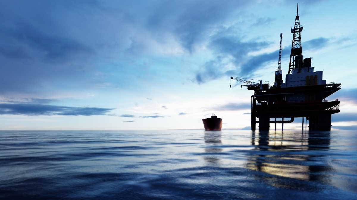 Offshore oil rig at dusk, calm sea.