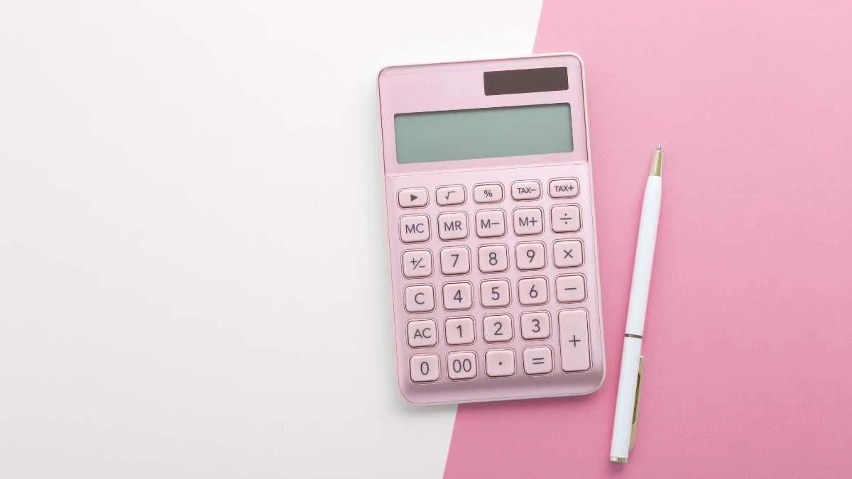 Pink calculator and white pen on a dual tone background