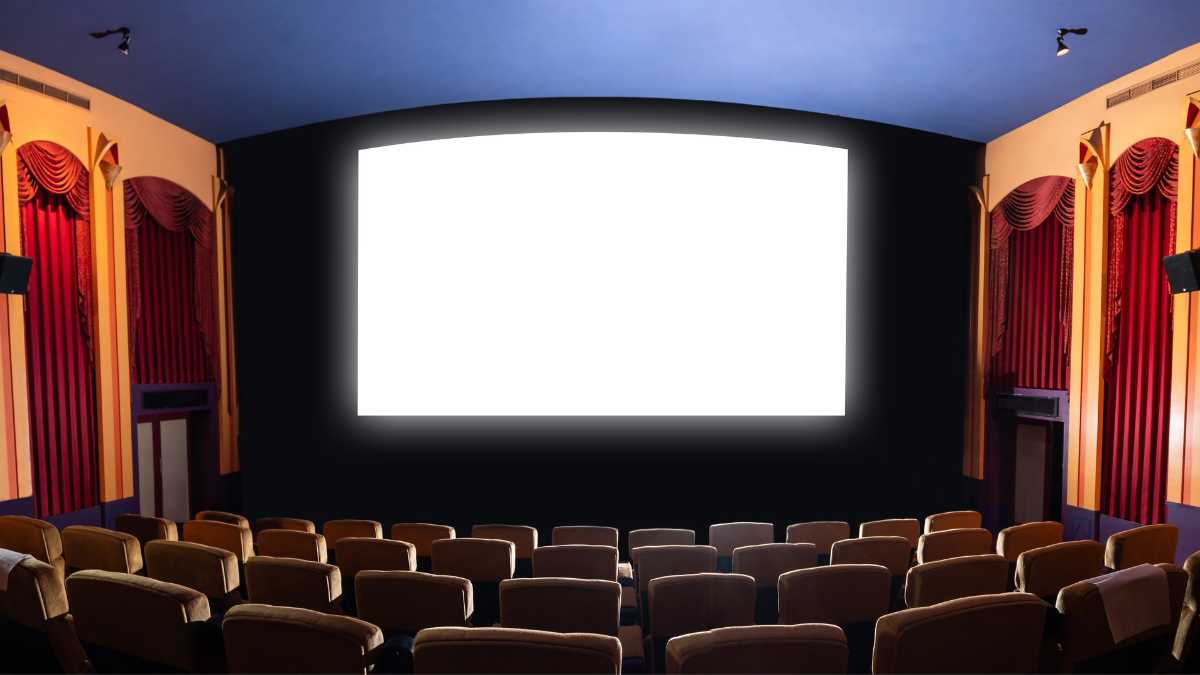 Empty cinema with a large blank screen and red curtains