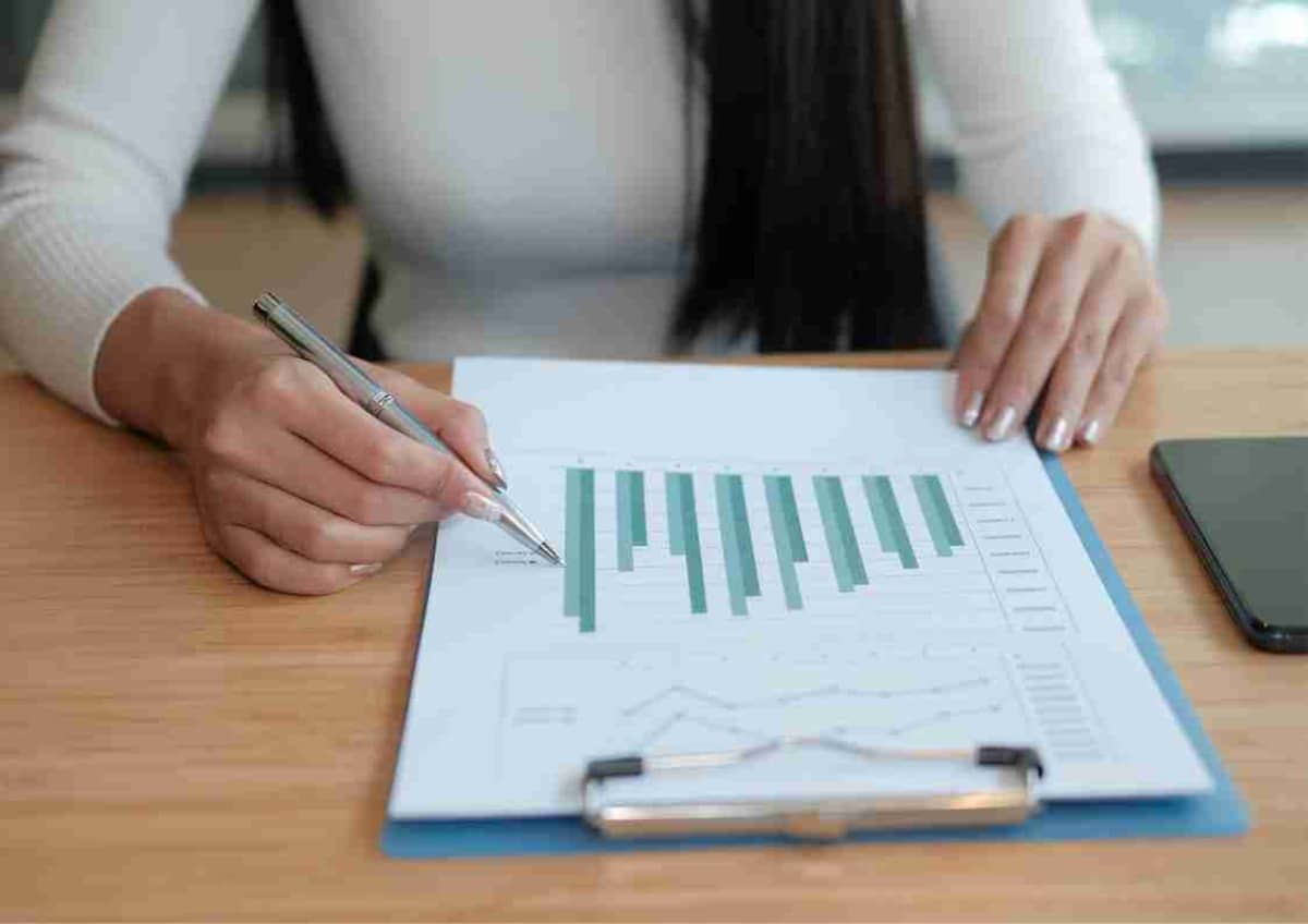 A person analyzing a bar graph on paper, indicative of financial review or planning