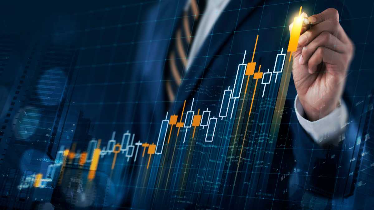 A businessman drawing on a glowing stock market chart with rising candlesticks