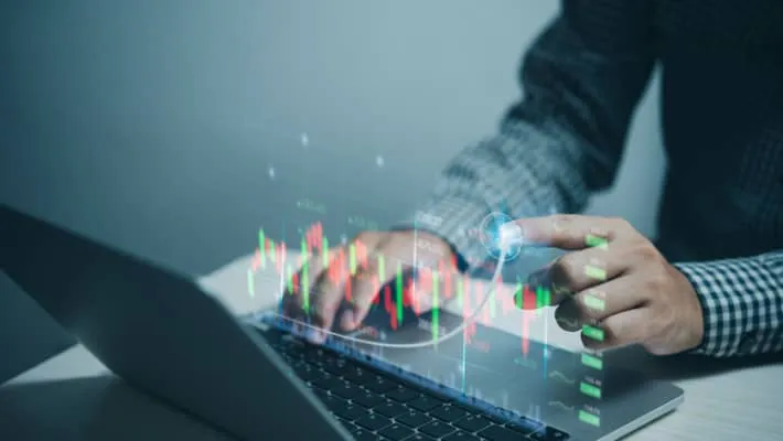 A man analysing the financial chart on a laptop