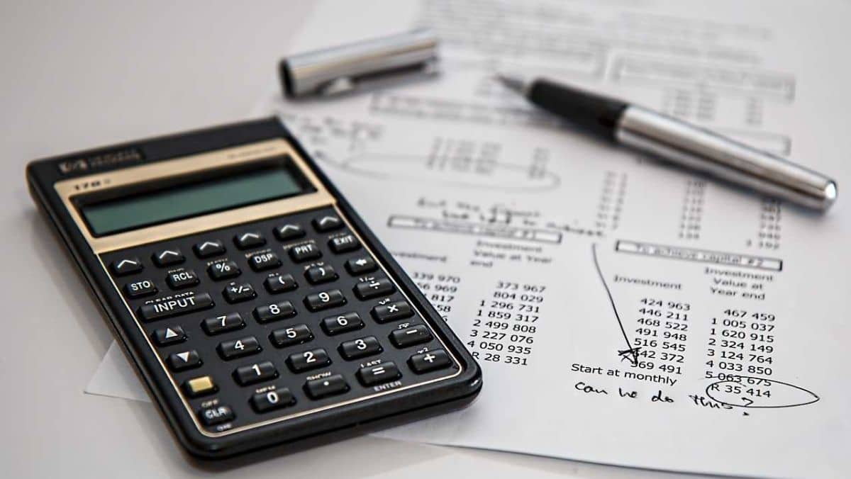 A calculator, a pen, and a financial statement on a table