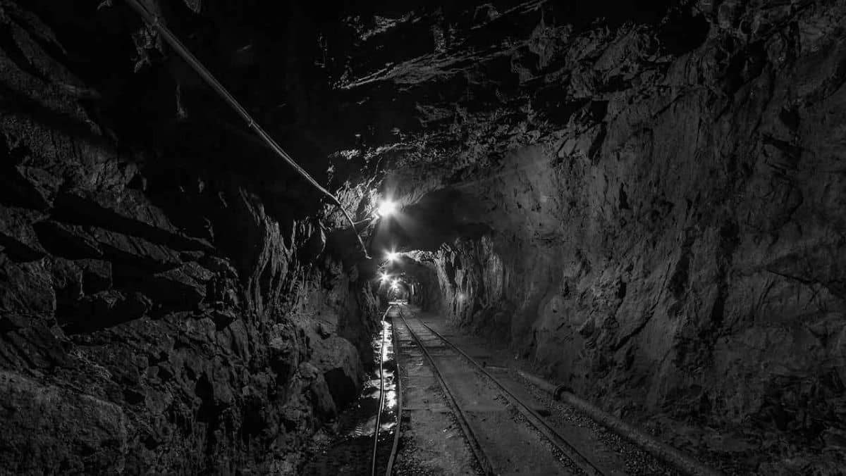 A dimmed gold mining tunnel with railways