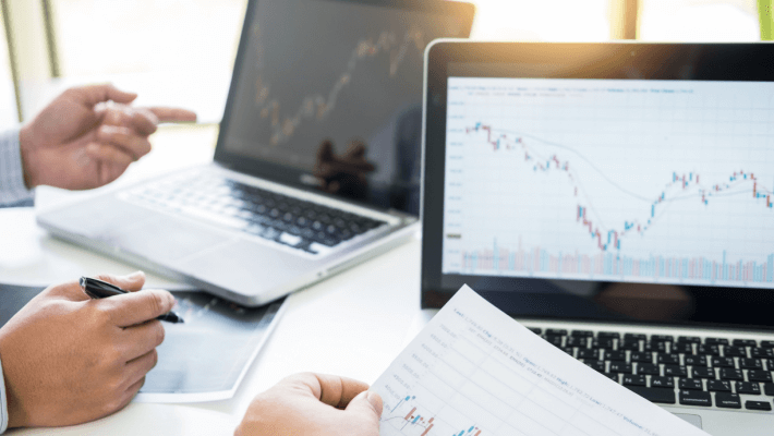 A man analysing the financial chart on a laptop