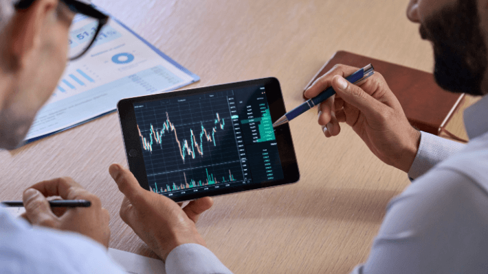 A man holding a pen, focused on a financial chart