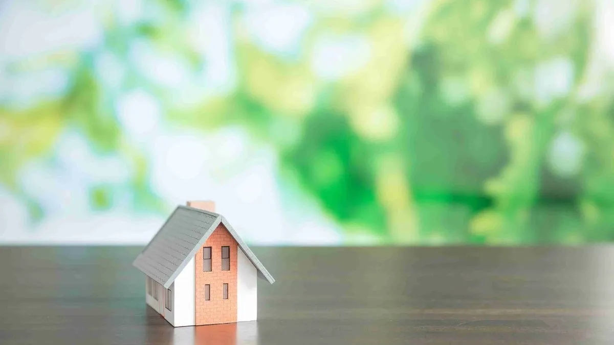 A miniature house on the table with a blurry background