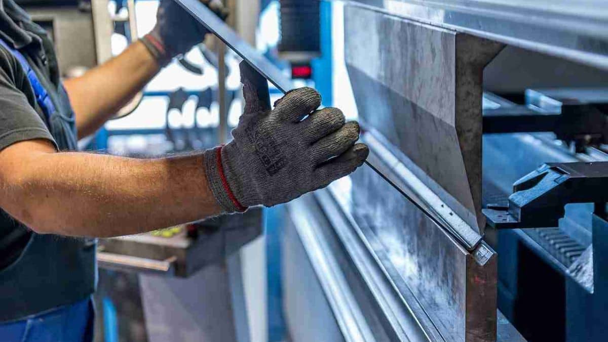 A person wearing gloves, holding steel bars