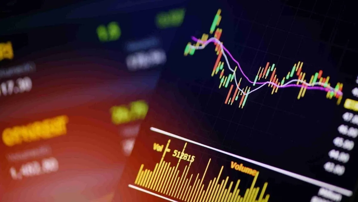 A trading chart and stock data displayed on digital screens