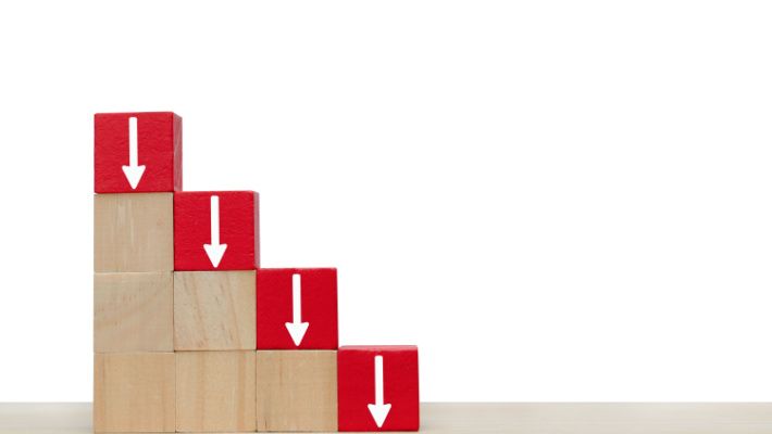 Blocks with red arrows pointing down, symbolizing decline