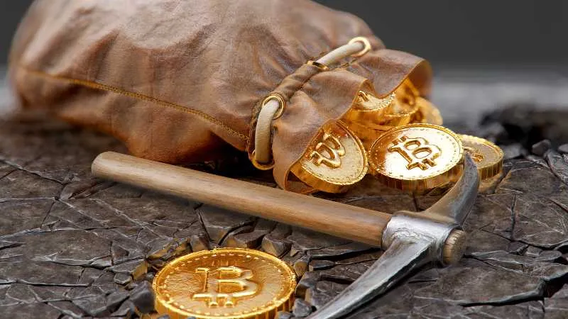 Gold Bitcoin tokens with a pickaxe and a sack, suggesting cryptocurrency mining