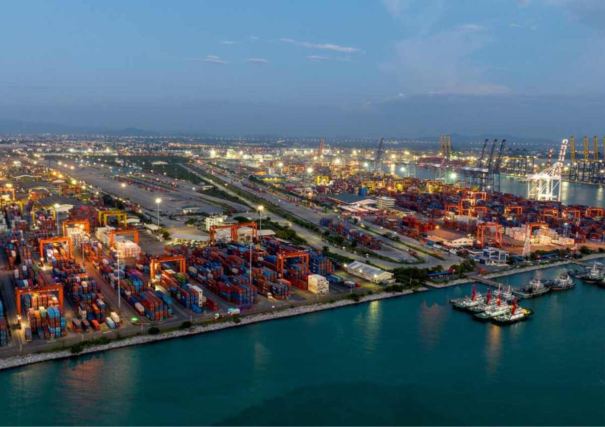 Aerial view of a busy port with shipping containers at dusk.