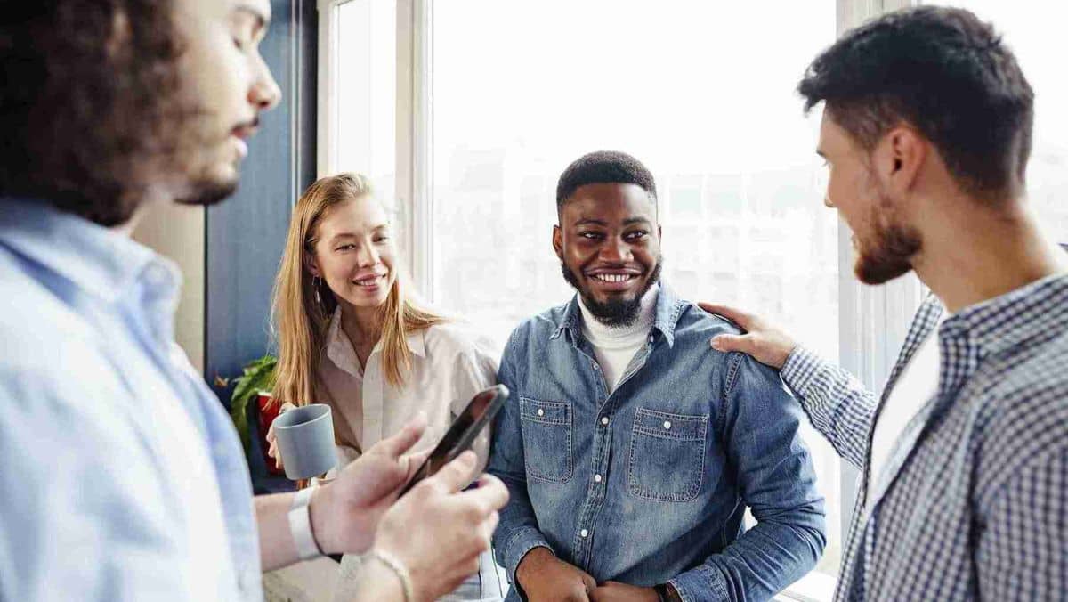 Individuals talk to each other with joy in an office setting