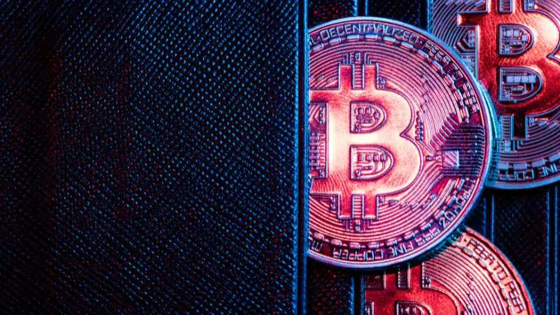 Red neon Bitcoin coins on a dark, textured surface, symbolizing digital currency