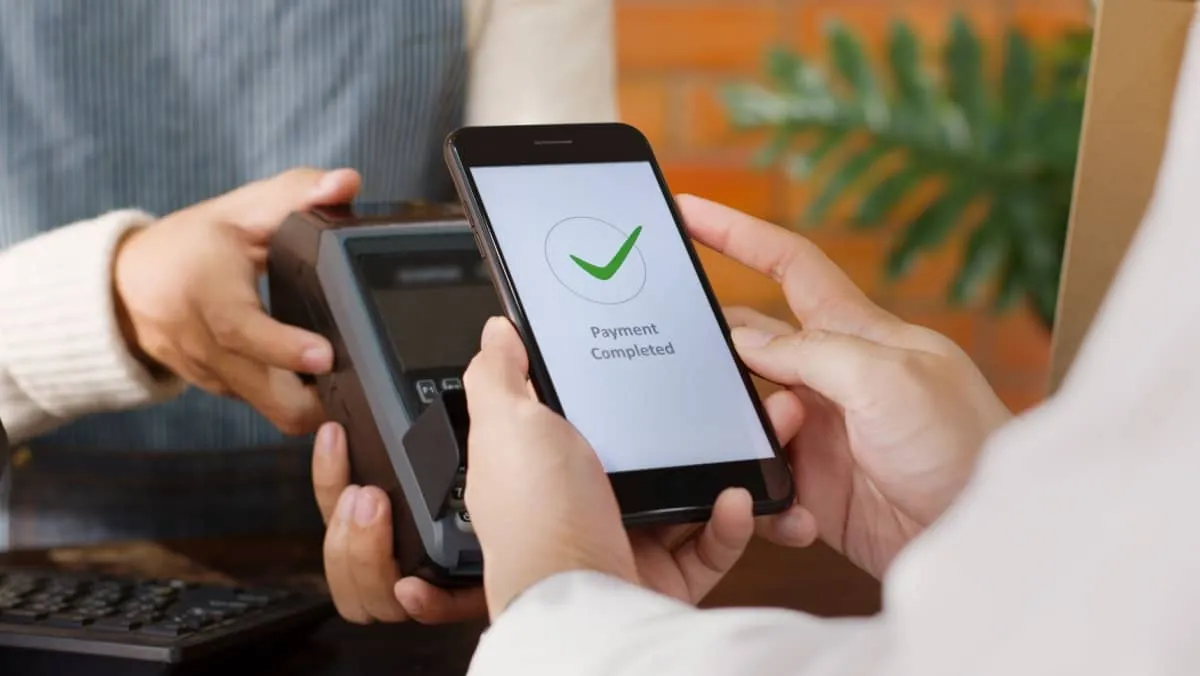 A customer seamlessly makes a payment at the cashier by using their phone and digital wallet