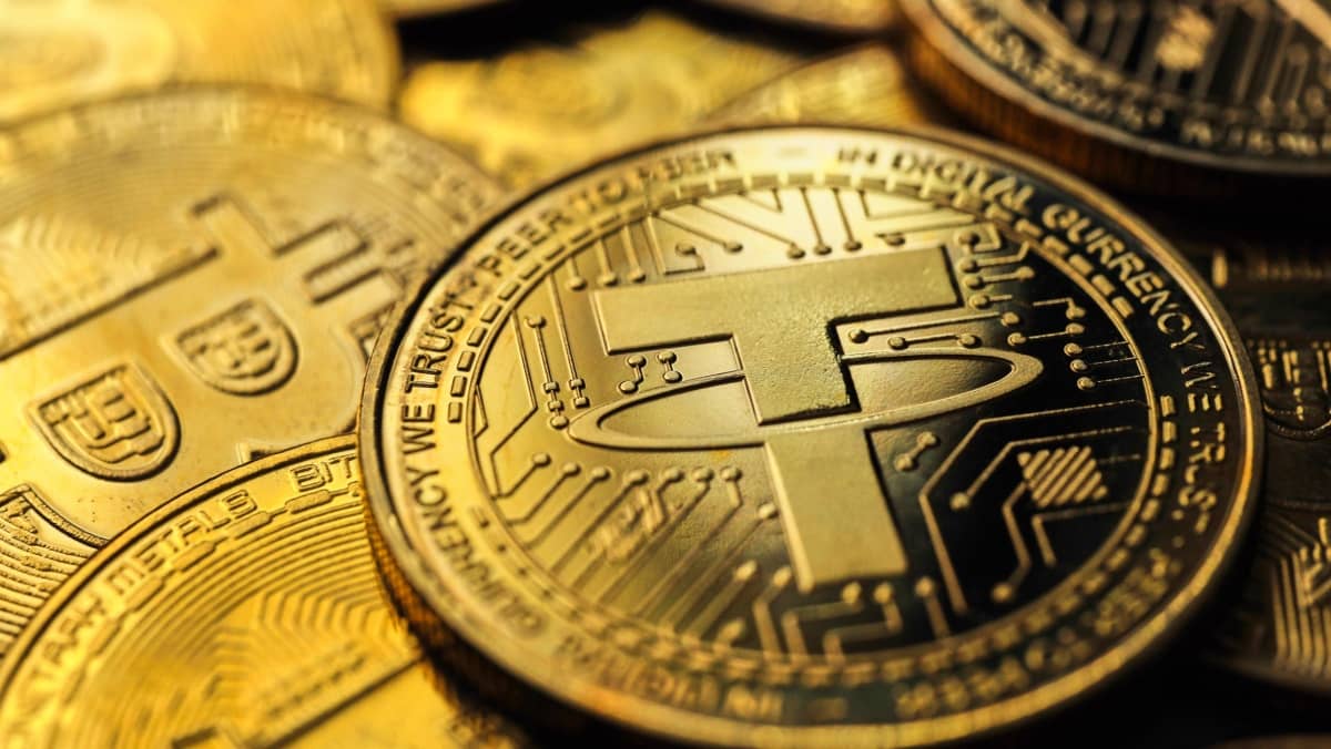 Focus view of a golden Tether USDT cryptocurrency coin with Bitcoin