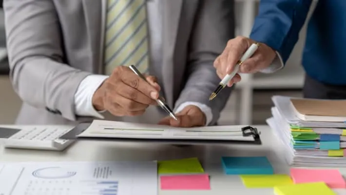 two people pointing at a document