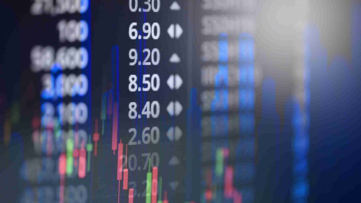 Stock market data on a digital screen and candlestick patterns