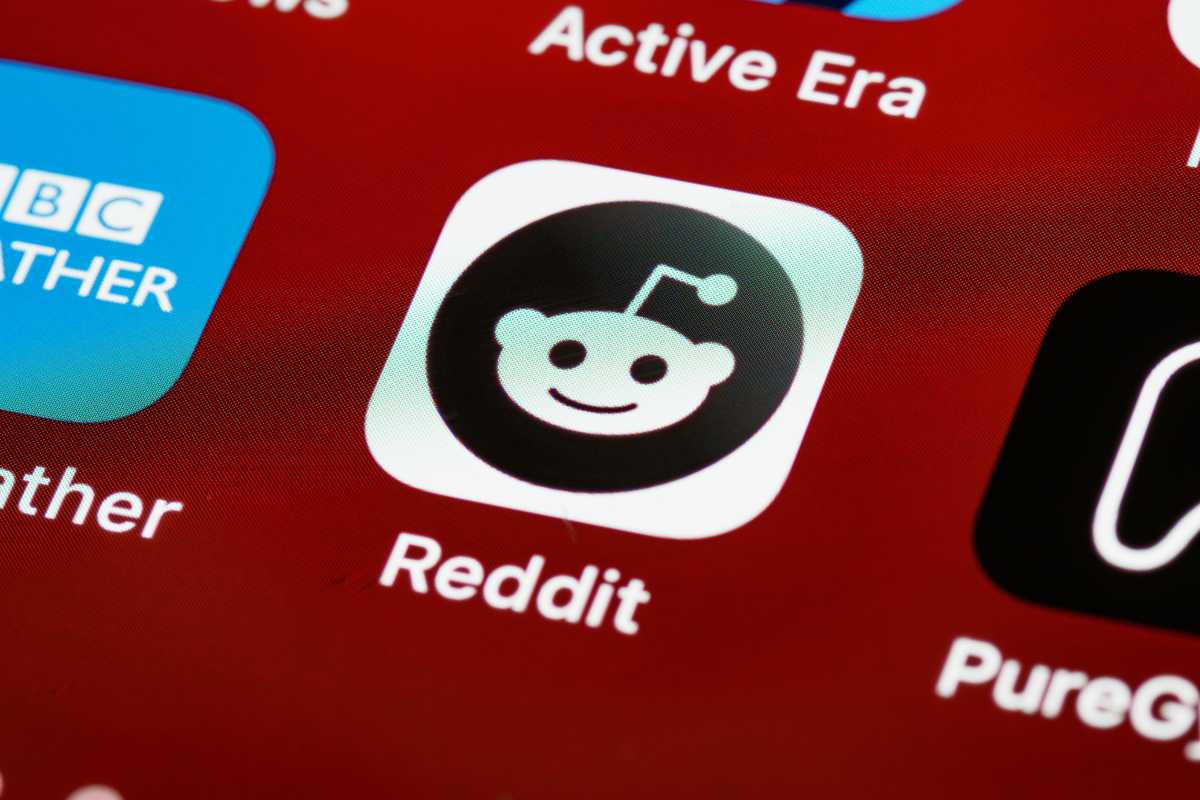 The Reddit app icon on a smartphone screen amidst other app icons