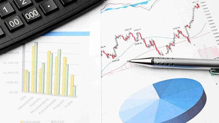 financial data chart beside a ballpen and a calculator 