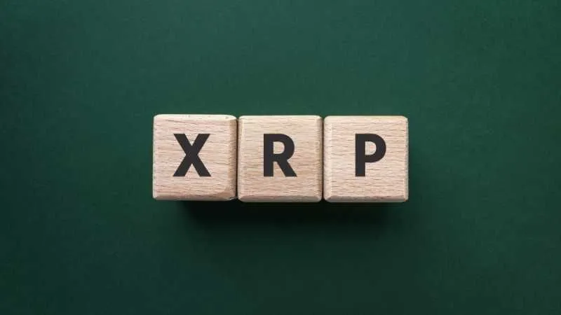 Wooden blocks spelling XRP on a green background