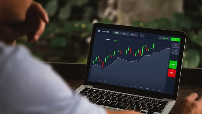 A man analysing bonds chart data on a computer screen