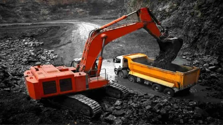 Excavator loading a dump truck in a mining site, illustrating heavy industry