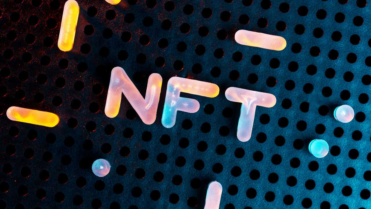 Letters "NFT" glowing on a perforated surface.