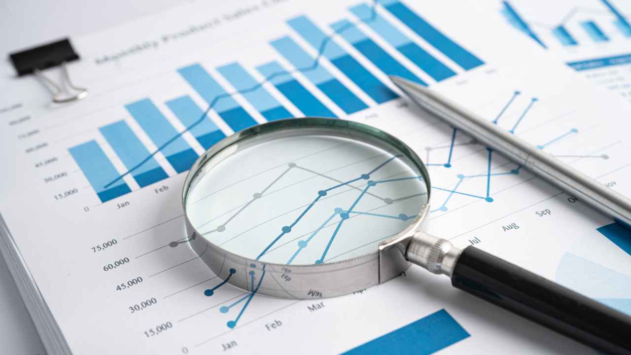 A magnifying glass and pen on a graph