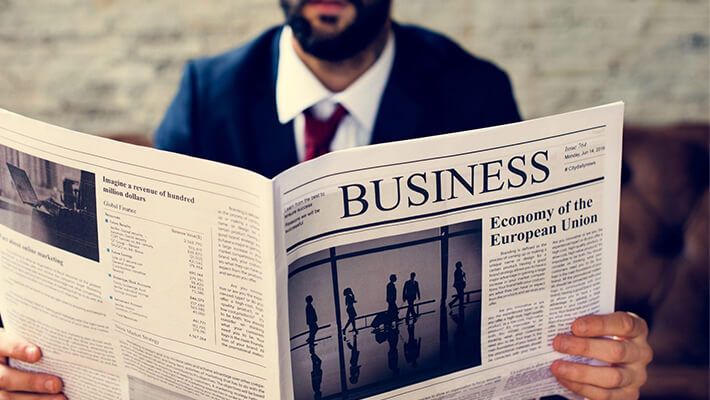 man in costume reads the business newspaper