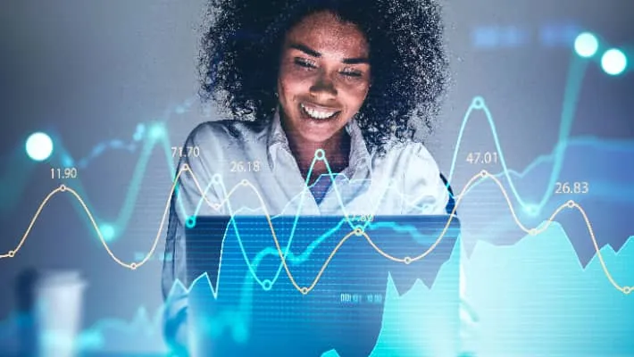 trader analysing financial graph on a laptop